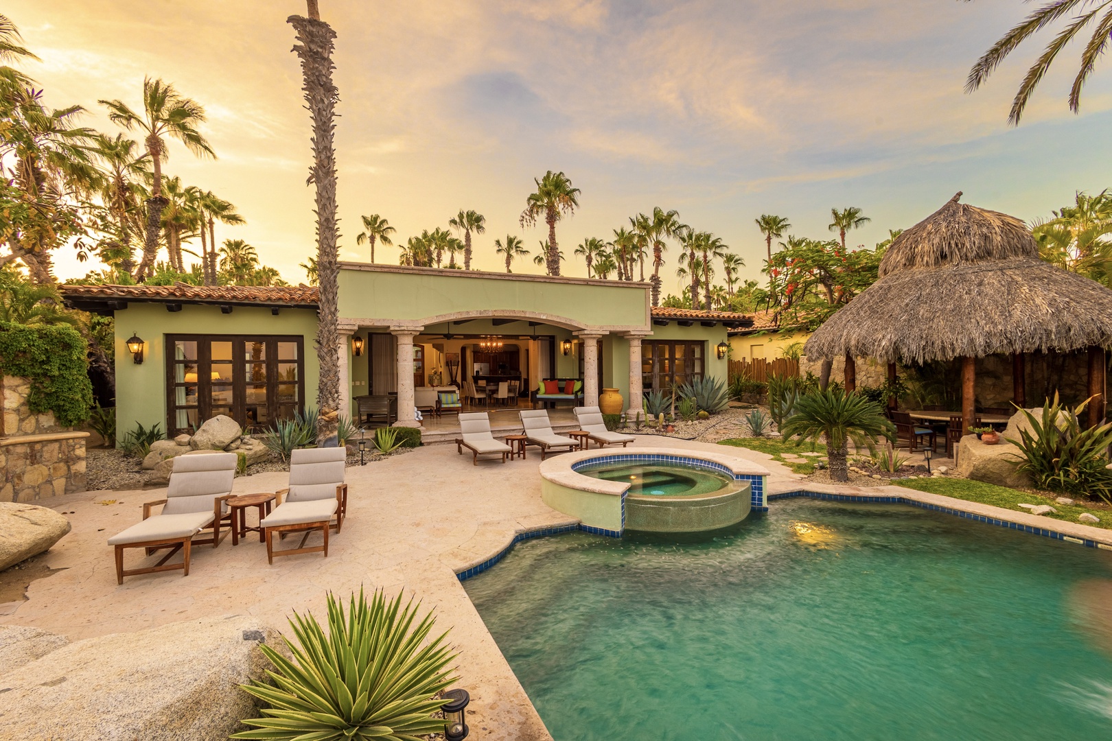 A tropical paradise where palm trees frame your private pool and palapa lounge—your perfect retreat for soaking up sunshine and warm evenings under desert skies.