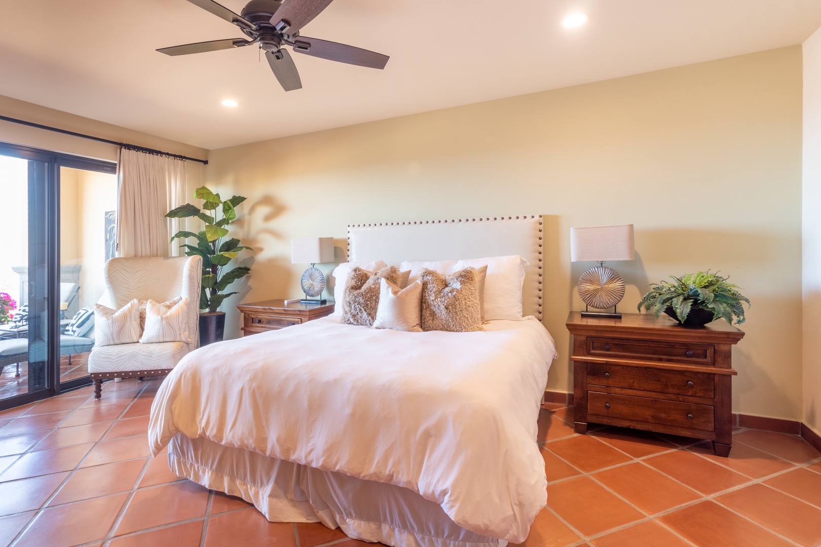 Step into your sunlit sanctuary with plush bedding, stylish décor, and a ceiling fan to keep you cool. A cozy seating nook and private balcony access await your morning coffee or evening unwind.