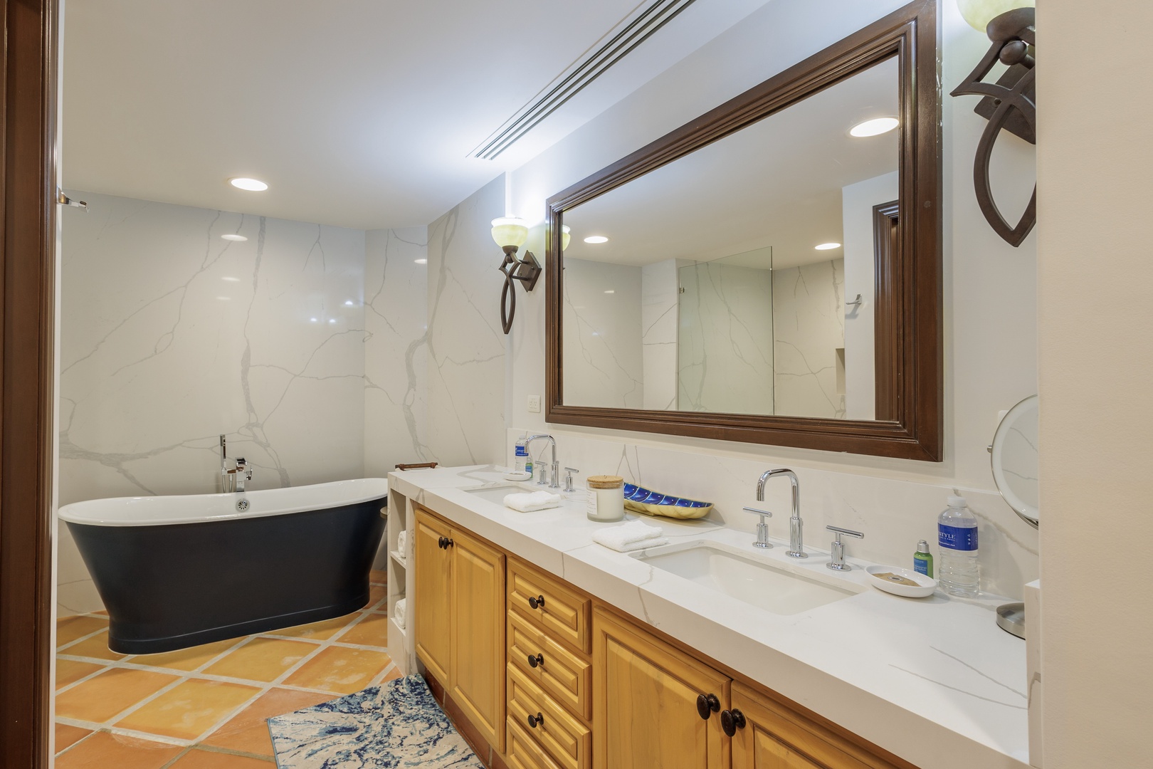 Indulge in a soothing soak in your elegant freestanding tub, or freshen up at the spacious double-sink vanity. Crisp marble tones and warm wood accents create a serene retreat.