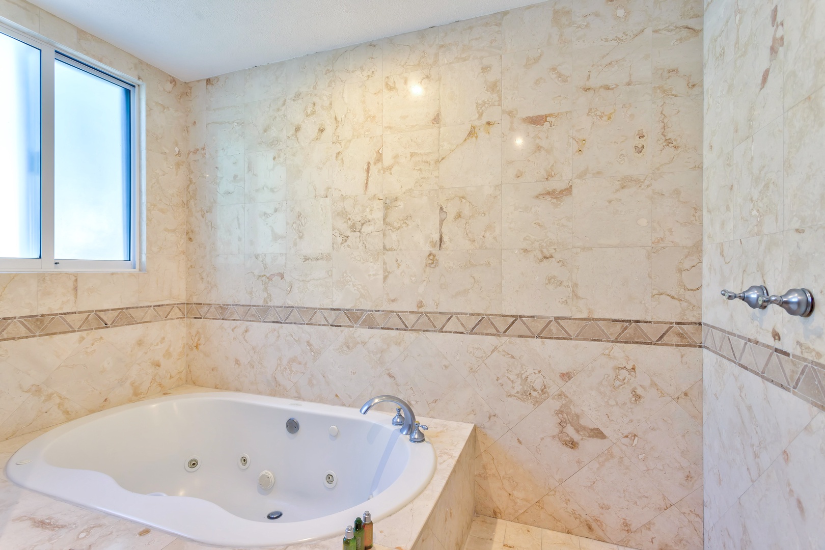 Unwind in your private marble-wrapped sanctuary featuring a luxurious jetted tub for the ultimate relaxation experience.