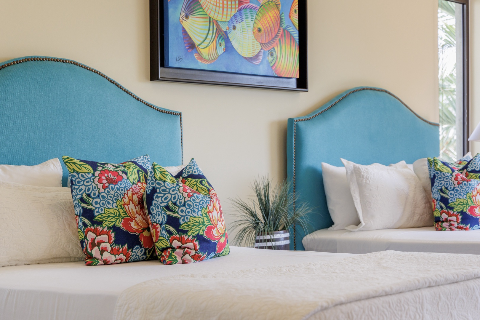 Drift into comfort in this tranquil bedroom with custom turquoise headboards, crisp linens, and vibrant tropical accents inviting you to unwind and recharge.