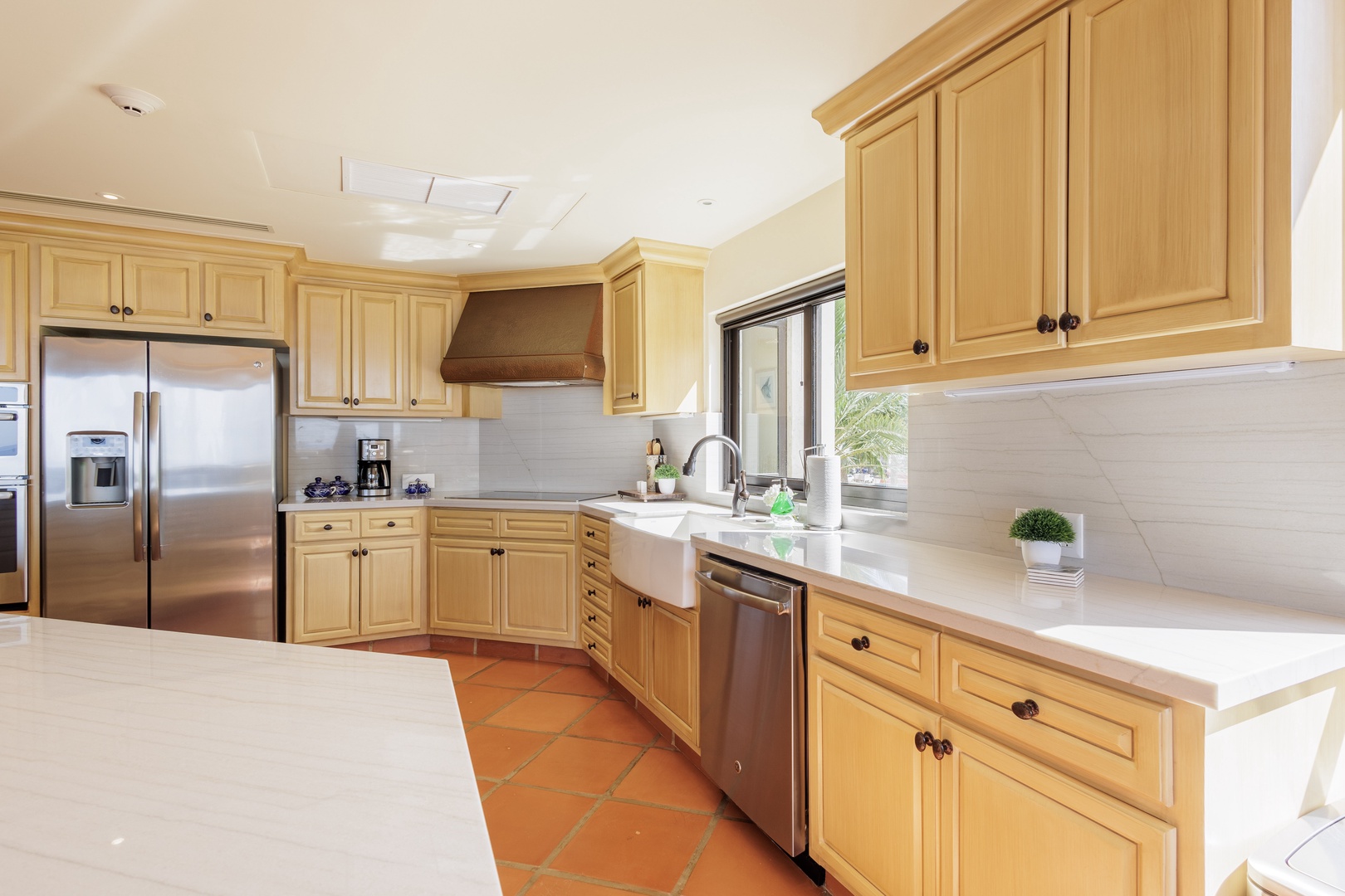 This bright, spacious kitchen has everything you need to feel at home—gleaming countertops, modern appliances, and warm natural light streaming through the windows, perfect for cooking your favorite meals.