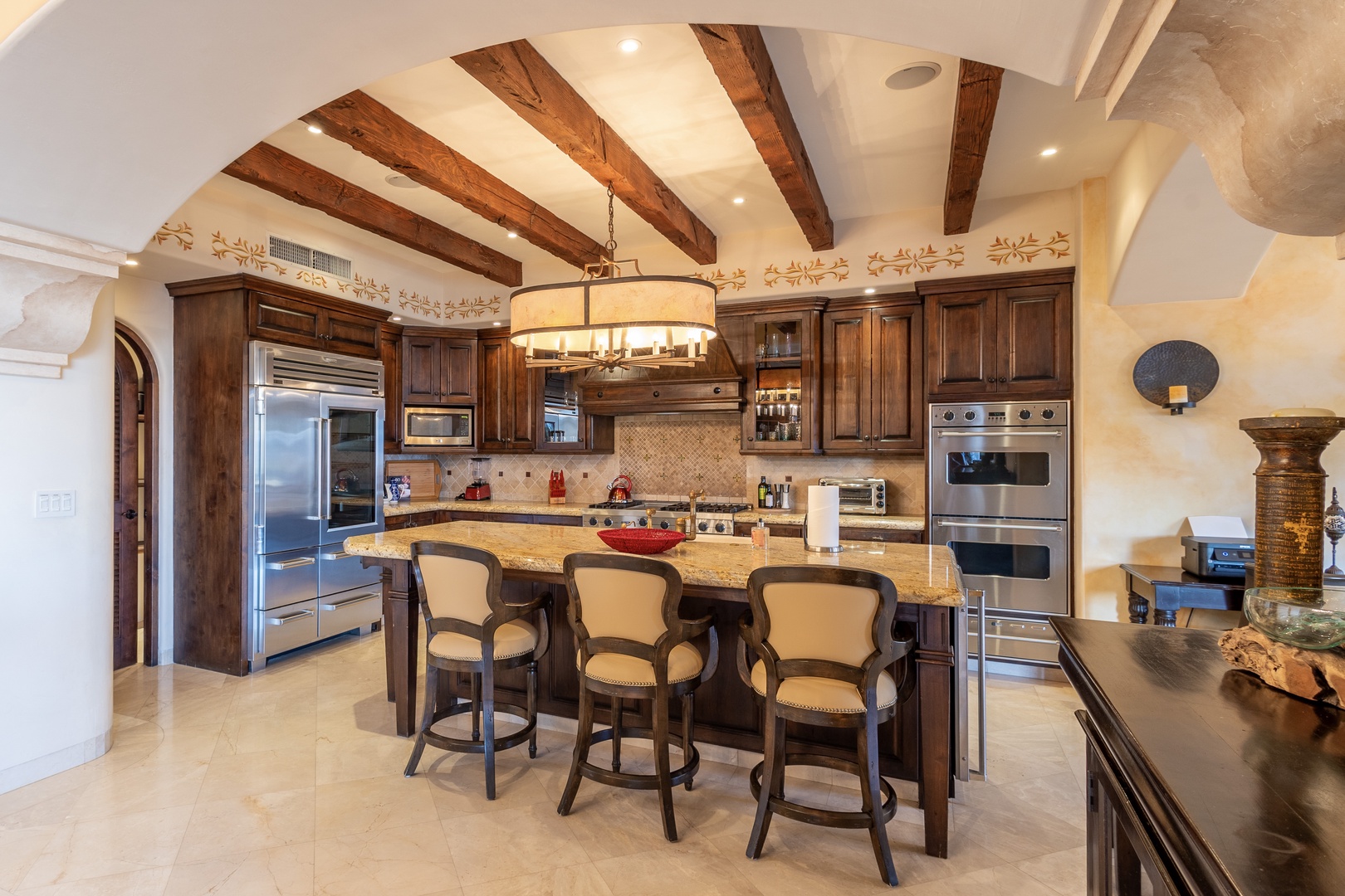 Step into a gourmet kitchen where rustic wooden beams meet elegant cabinetry. Gather around the spacious island with seating for memorable meals and conversation in this inviting culinary haven.
