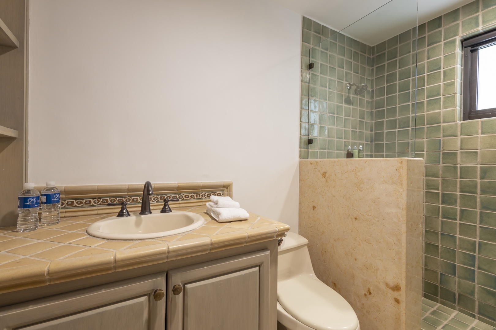 Freshen up in your private bathroom with elegant tile details, a refreshing rain shower, and thoughtful touches like bottled water waiting for you.