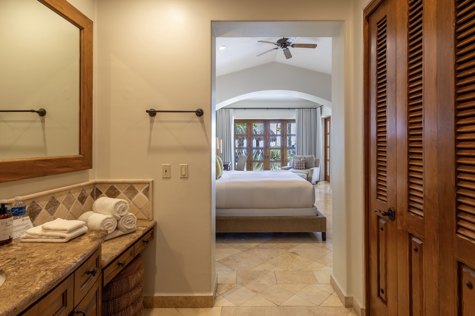 Your private suite flows seamlessly from the elegant bathroom to your serene bedroom, where soft linens and tropical breezes await.