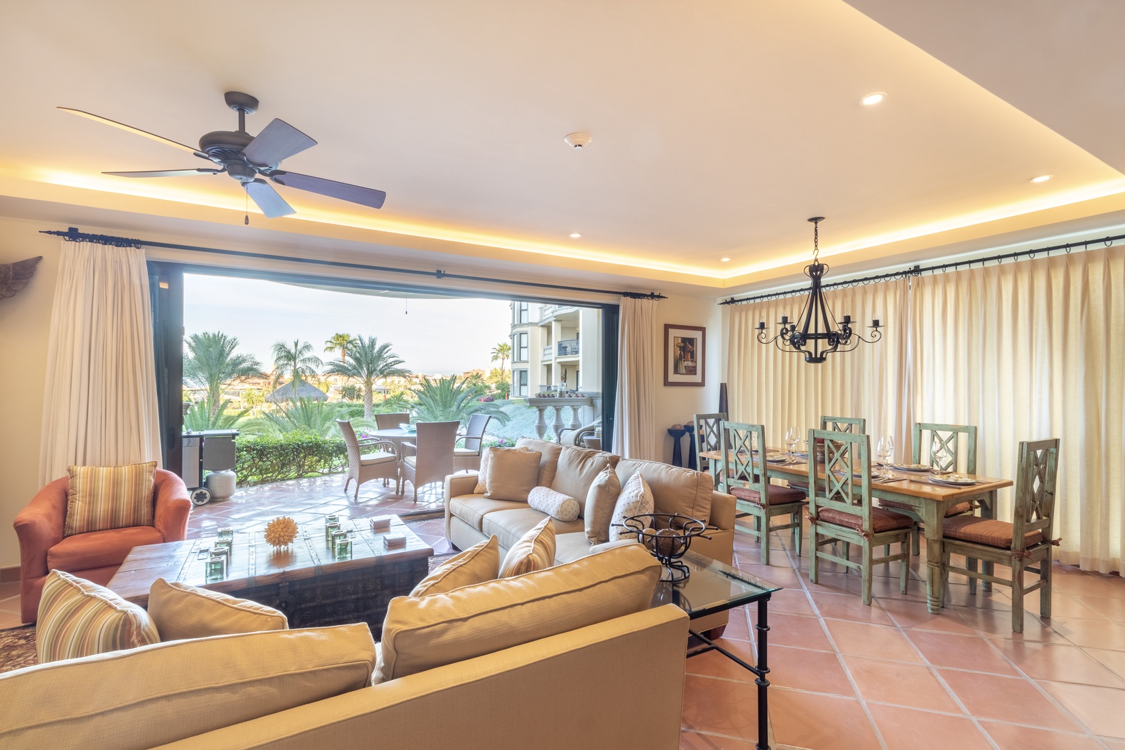 Your spacious living area flows seamlessly to your private patio, where lush palms frame inviting poolside lounging and sunny garden views await your relaxation.