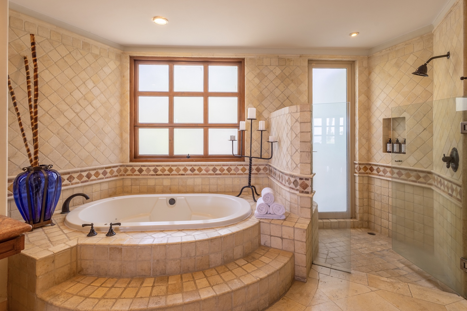 Indulge in your own private spa retreat with this luxurious sunken tub and spacious walk-in shower, perfect for unwinding after your adventures.