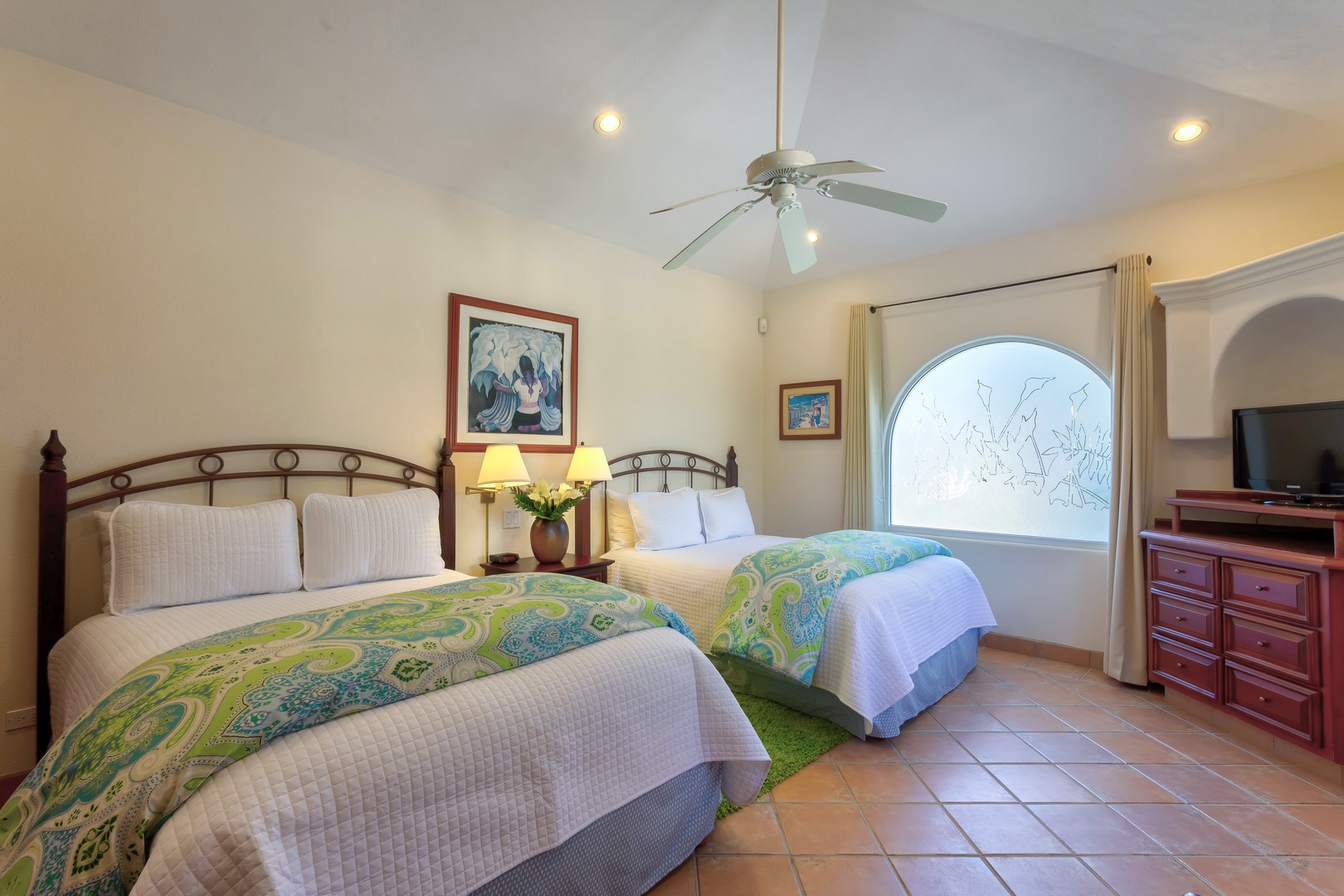 Rest peacefully in your twin-bed retreat with crisp linens, warm lighting, and an arched window brightening your mornings.
