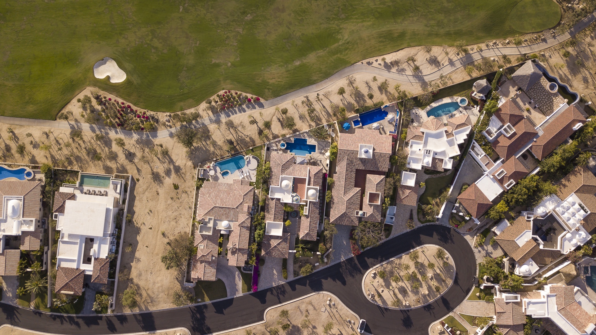 Aerial view of beachfront vacation properties featuring private pools and direct beach access in an exclusive coastal community.