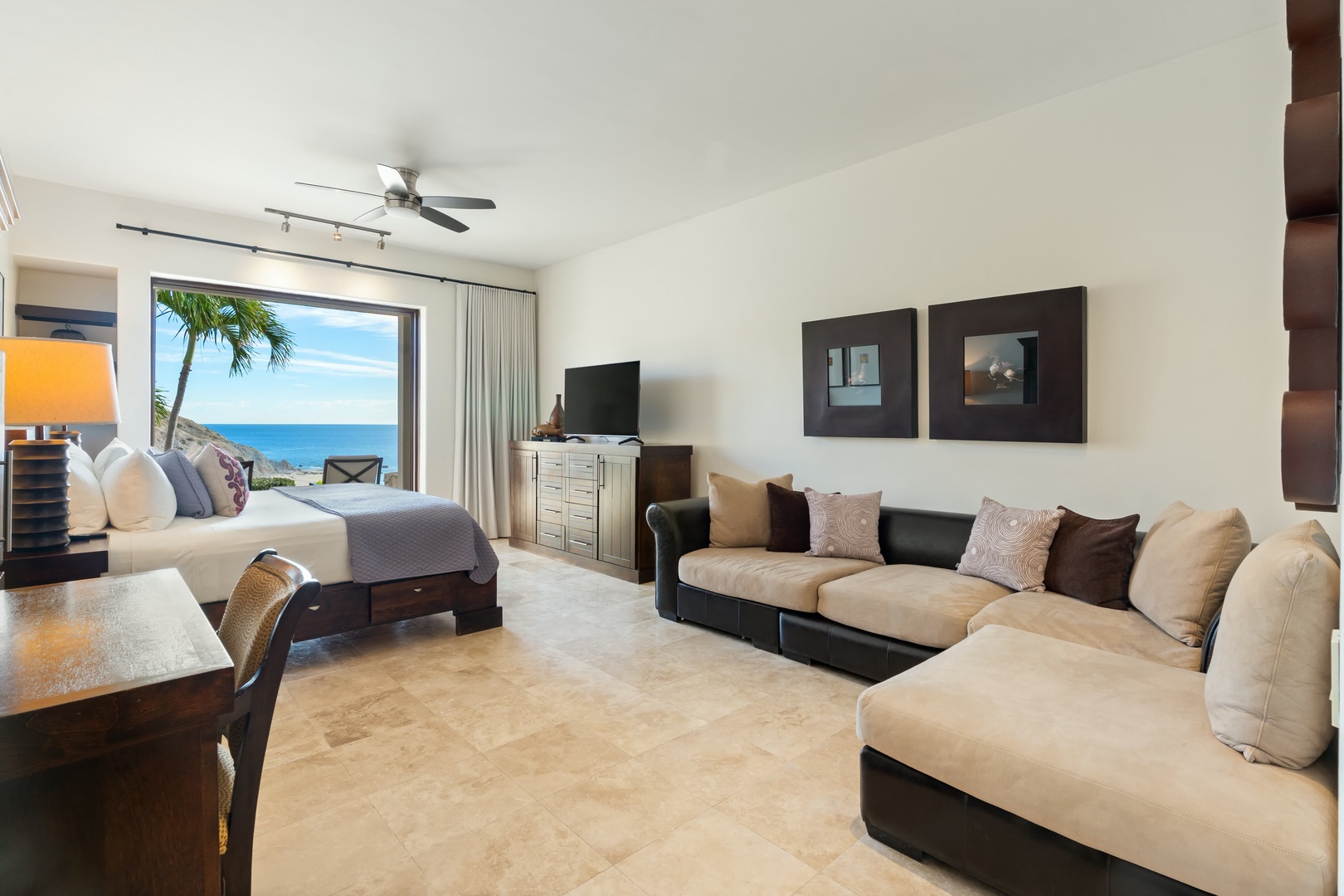 Your spacious suite combines bedroom comfort with living room luxury, all framed by stunning ocean views through floor-to-ceiling windows.