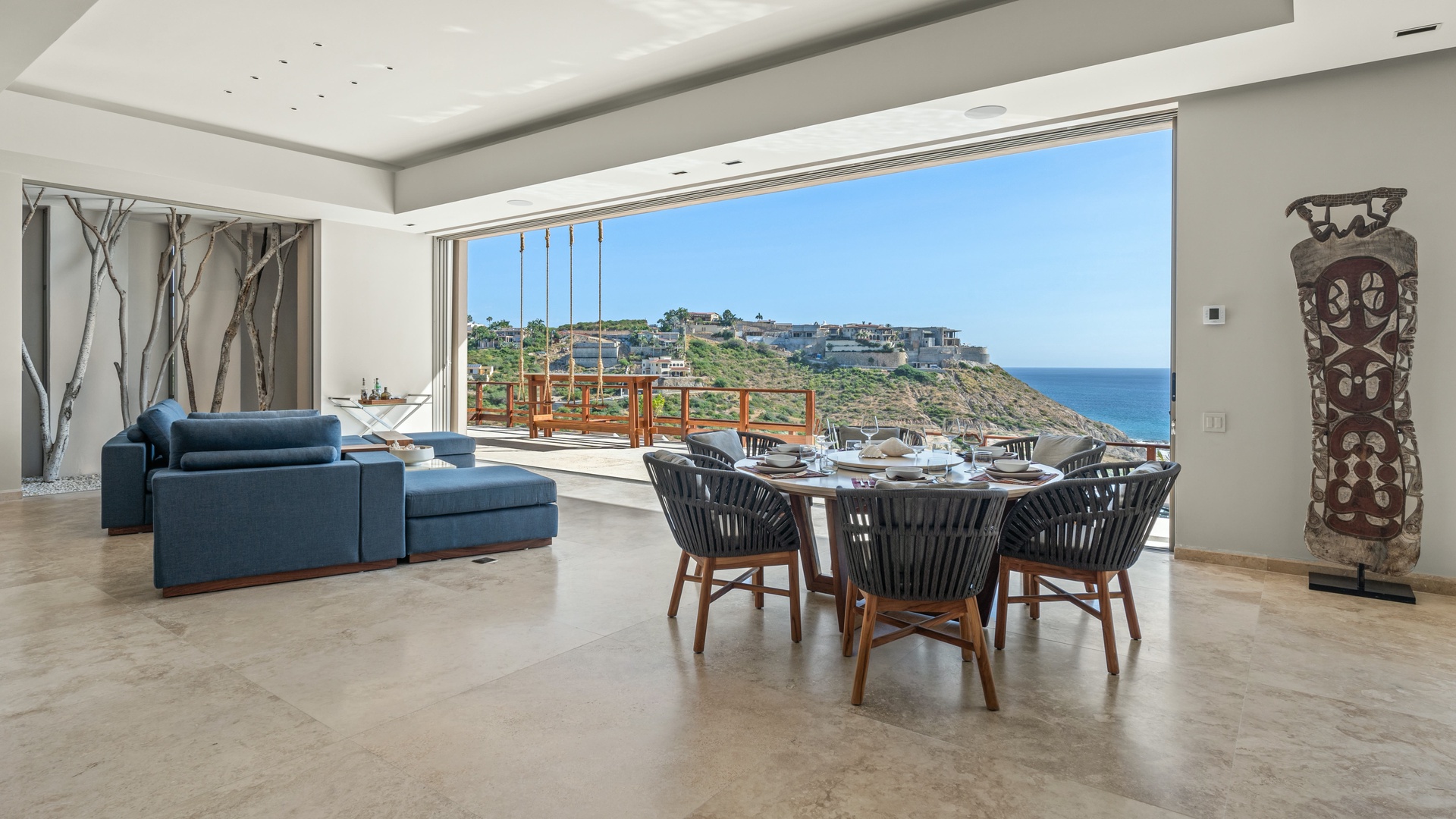 Imagine gathering here for meals with breathtaking views of the coastal cliffs through floor-to-ceiling windows. The modern living space flows seamlessly onto your private terrace, perfect for morning coffee or sunset dining.
