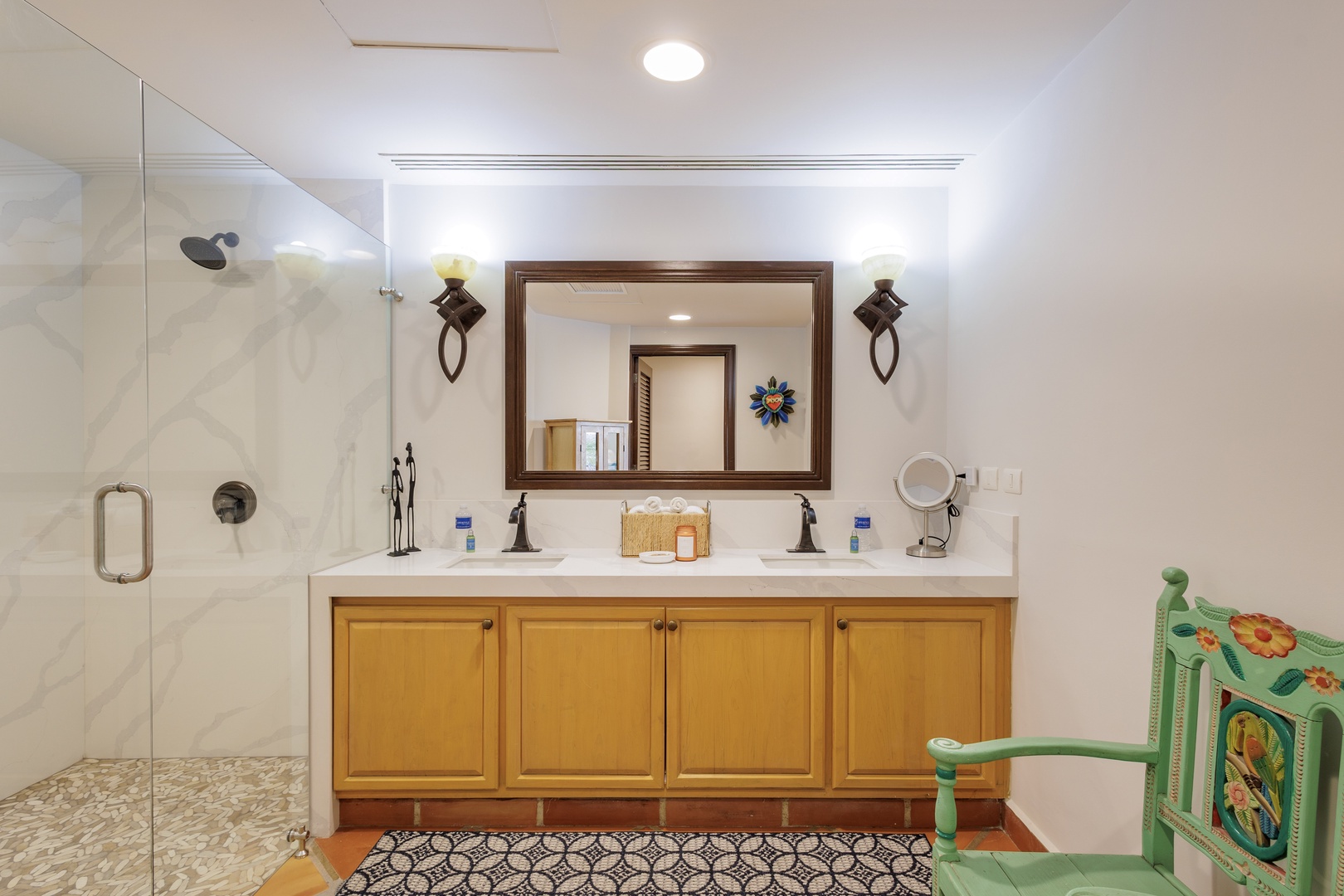 Your private bathroom features dual vanities, a spacious walk-in shower with marble tile, and thoughtful lighting—all designed to make your mornings feel effortless and refreshing.
