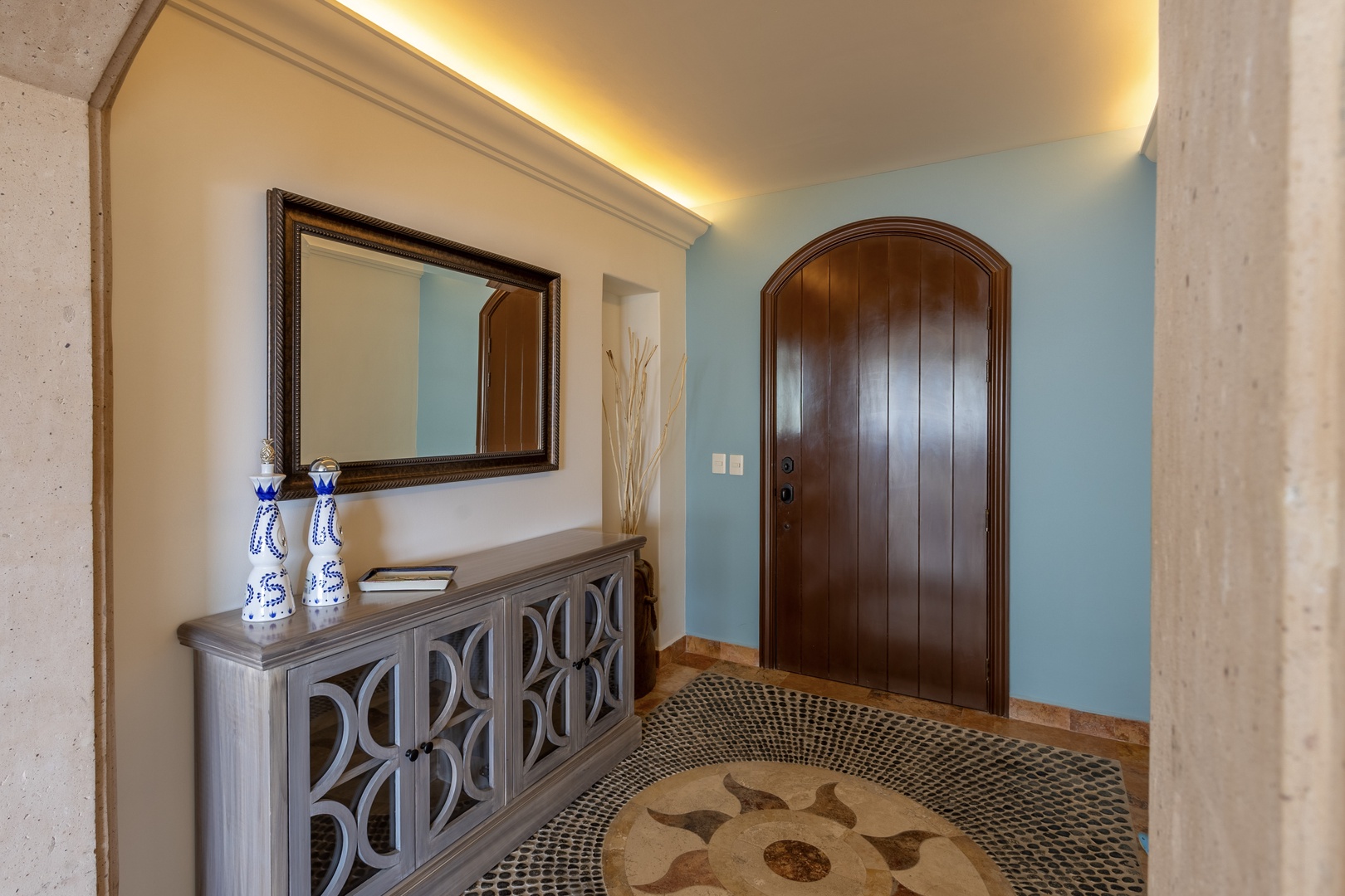 Your elegant foyer welcomes you with warm lighting, sophisticated decor, and beautiful mosaic flooring that sets the tone for your refined stay.
