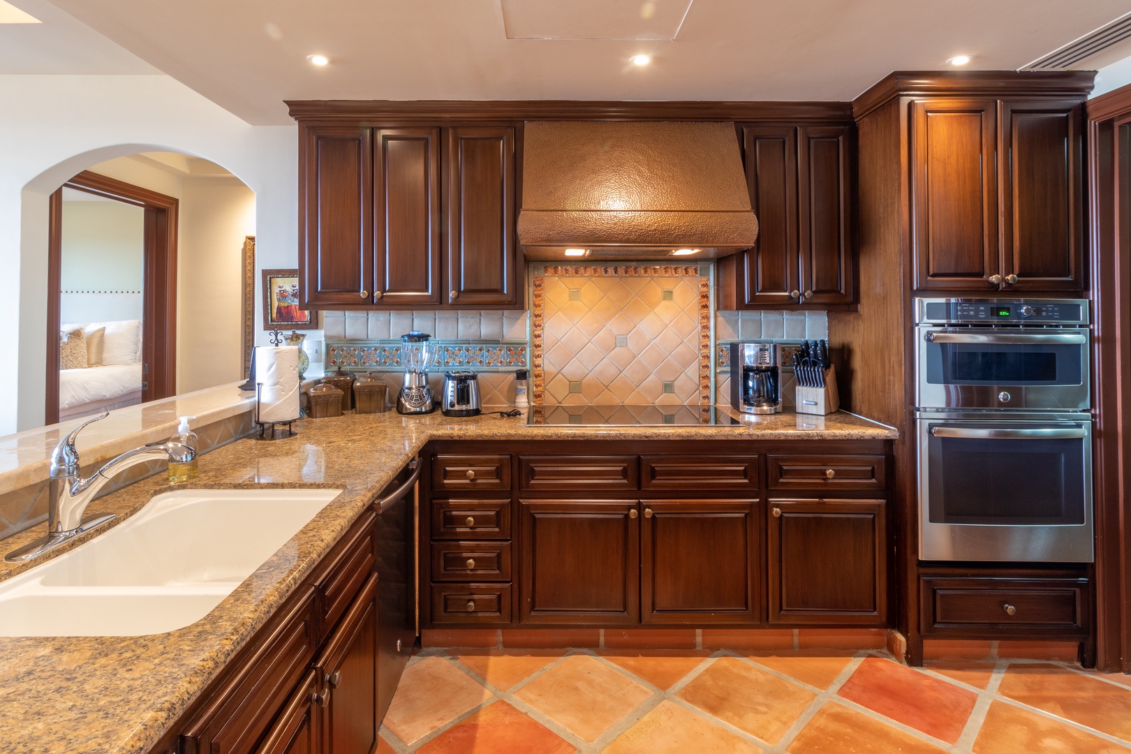 Your gourmet kitchen invites culinary adventures with granite countertops, rich wood cabinetry, double ovens, and elegant tile backsplash. Sunlit and spacious, it's perfect for creating vacation memories together.