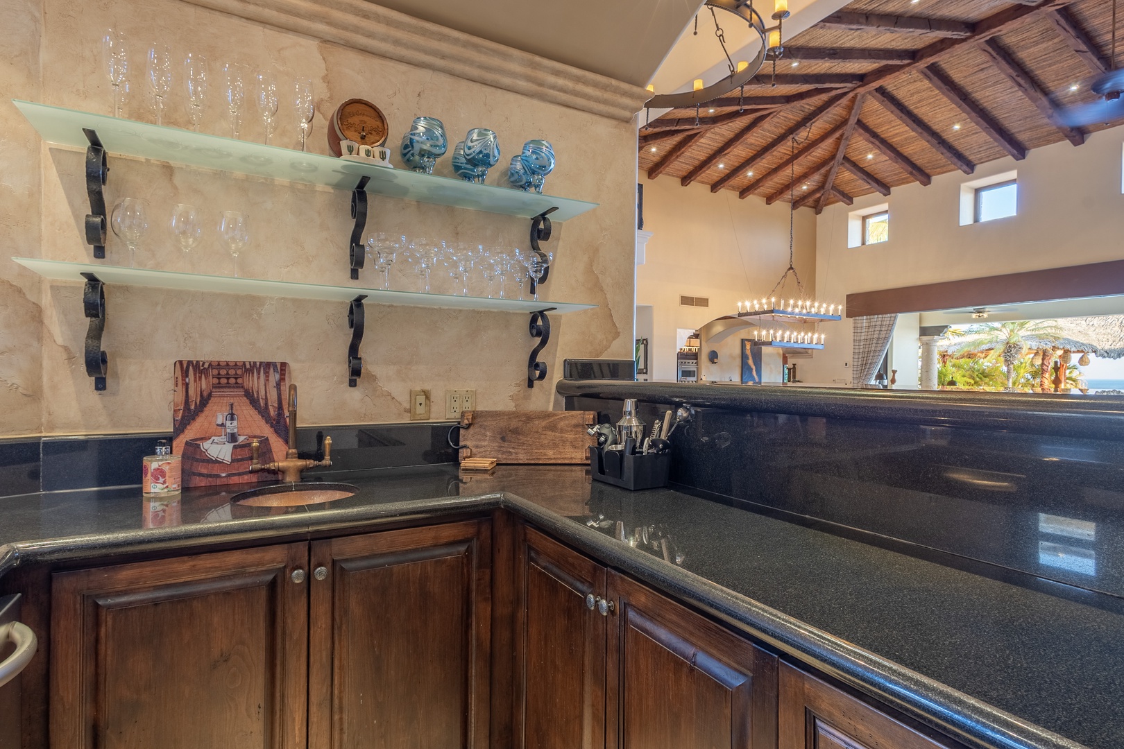 Your fully-equipped kitchen features stylish open shelving, sleek granite counters, and warm wood cabinetry—perfect for preparing meals while enjoying natural light and stunning ocean views.