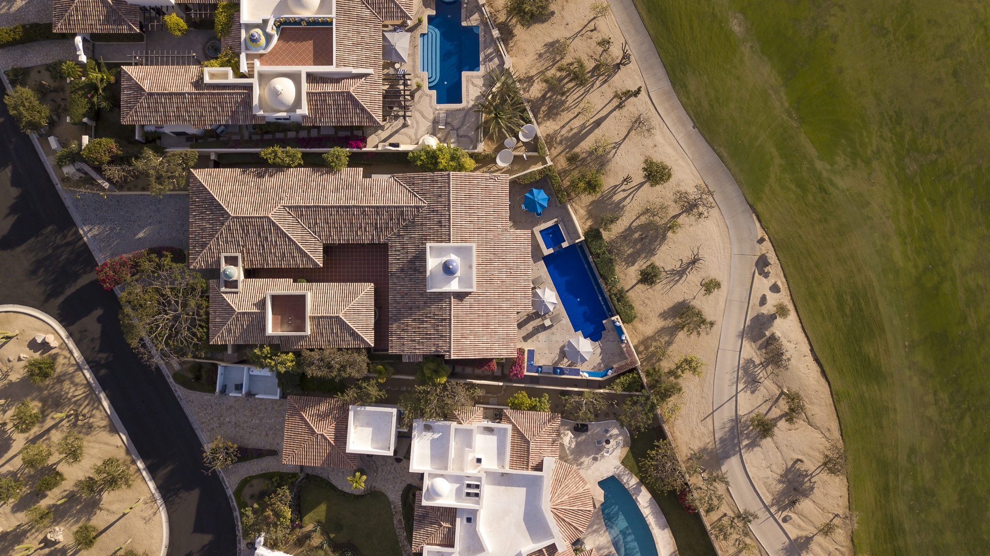 Aerial view showcasing the villa complex with private pools and Mediterranean-style architecture amid landscaped grounds.