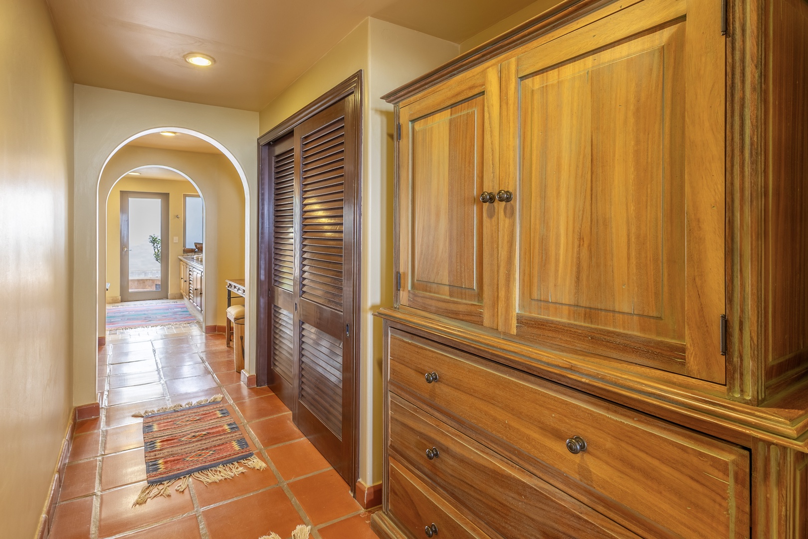 Step into your private hallway, where handcrafted wooden wardrobes and terracotta tiles create a warm, inviting atmosphere for storing your belongings in style.