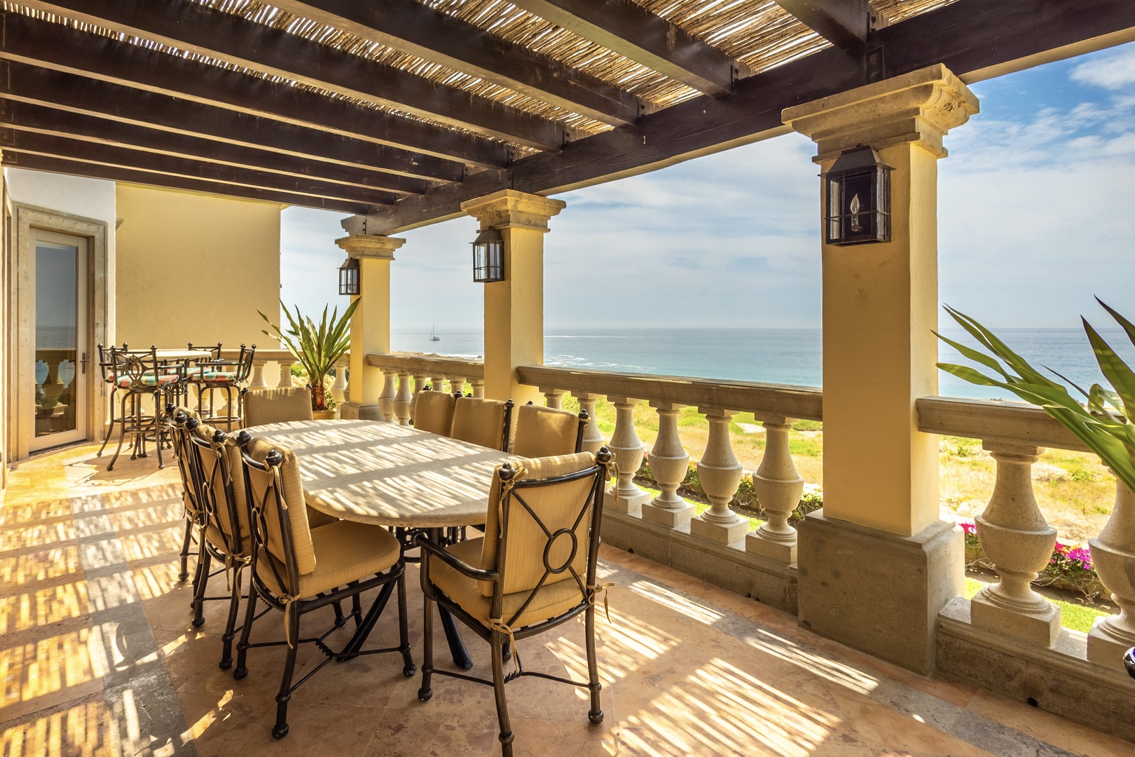 Imagine sipping your morning coffee as sunlight filters through the pergola, casting dappled shadows on this elegant terrace overlooking the sparkling sea—your own private coastal retreat awaits.