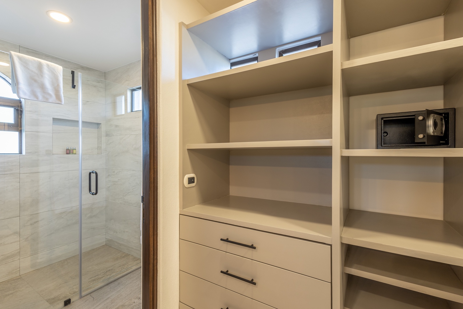 Your private suite features spacious storage with built-in shelving and drawers, plus an in-room safe for your peace of mind. The elegant marble shower awaits after your adventures.