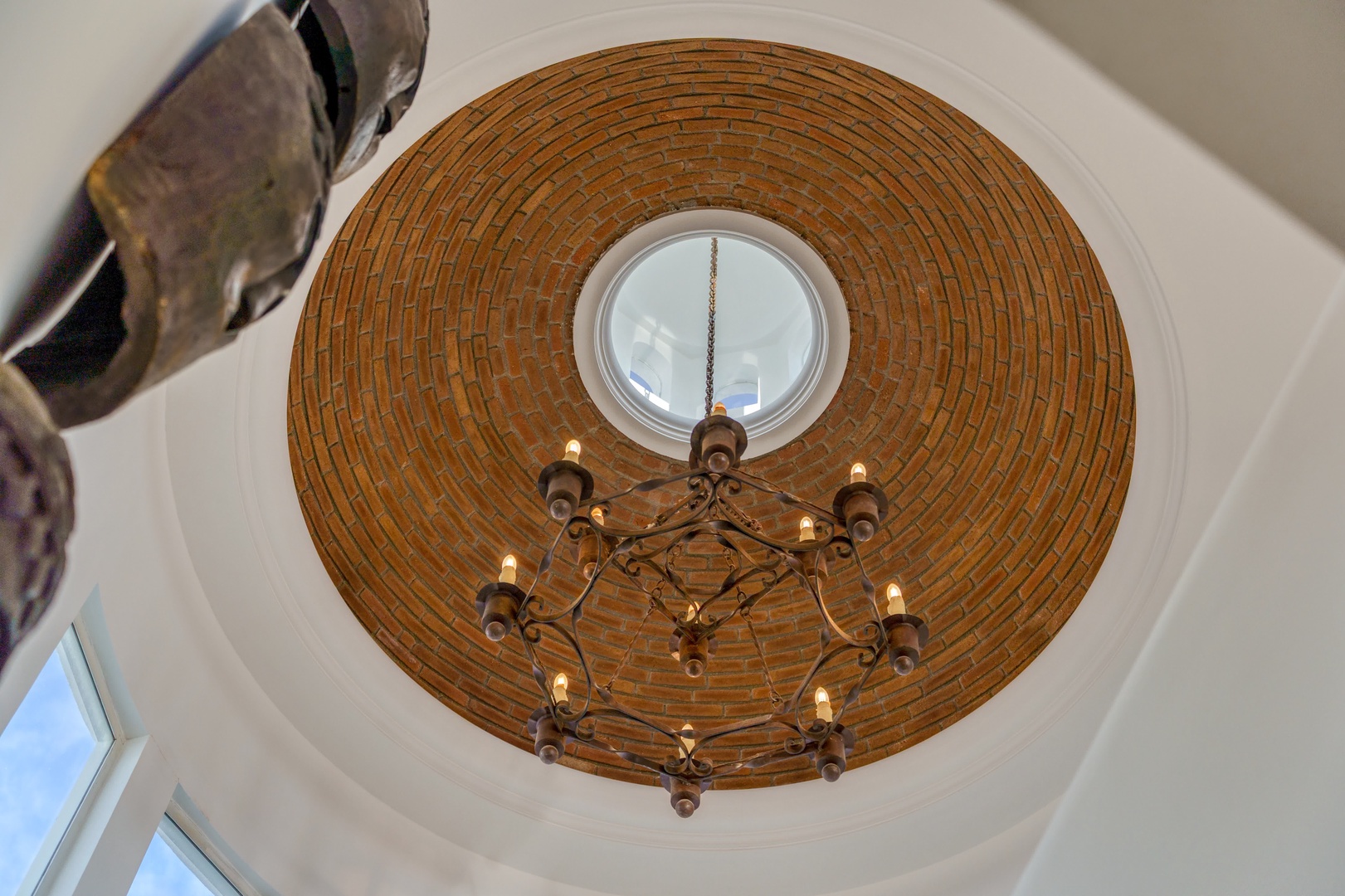 Look up to discover stunning architectural details—this circular brick dome with elegant chandelier creates a dramatic focal point above.