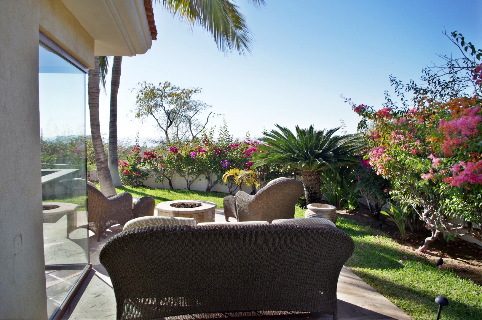 Unwind in your private outdoor oasis, where lush tropical gardens and cozy seating invite you to relax beneath swaying palms and vibrant blooms.