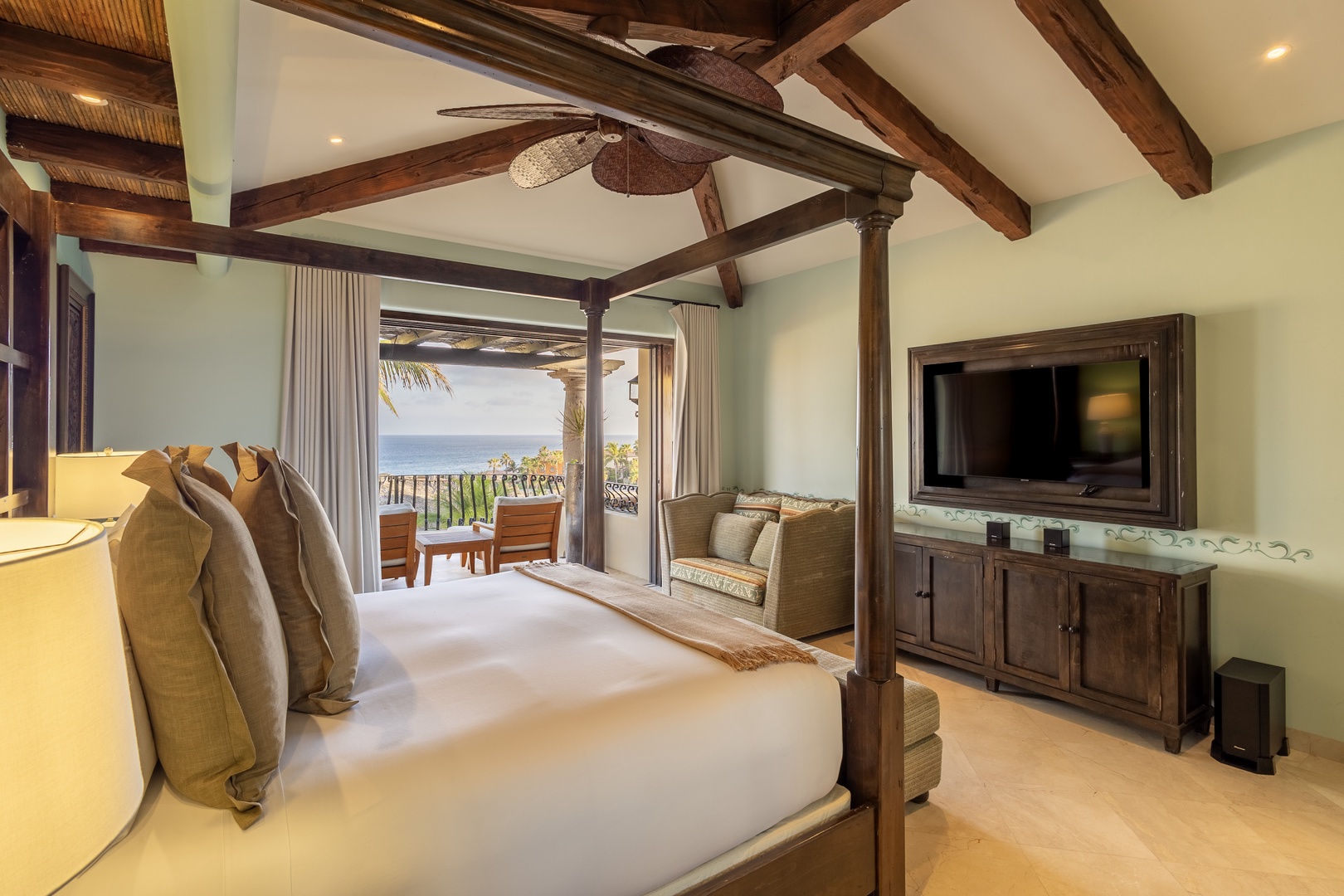 Your sanctuary features exposed wood beams and a four-poster bed, opening to a private terrace with ocean views that invite endless relaxation.
