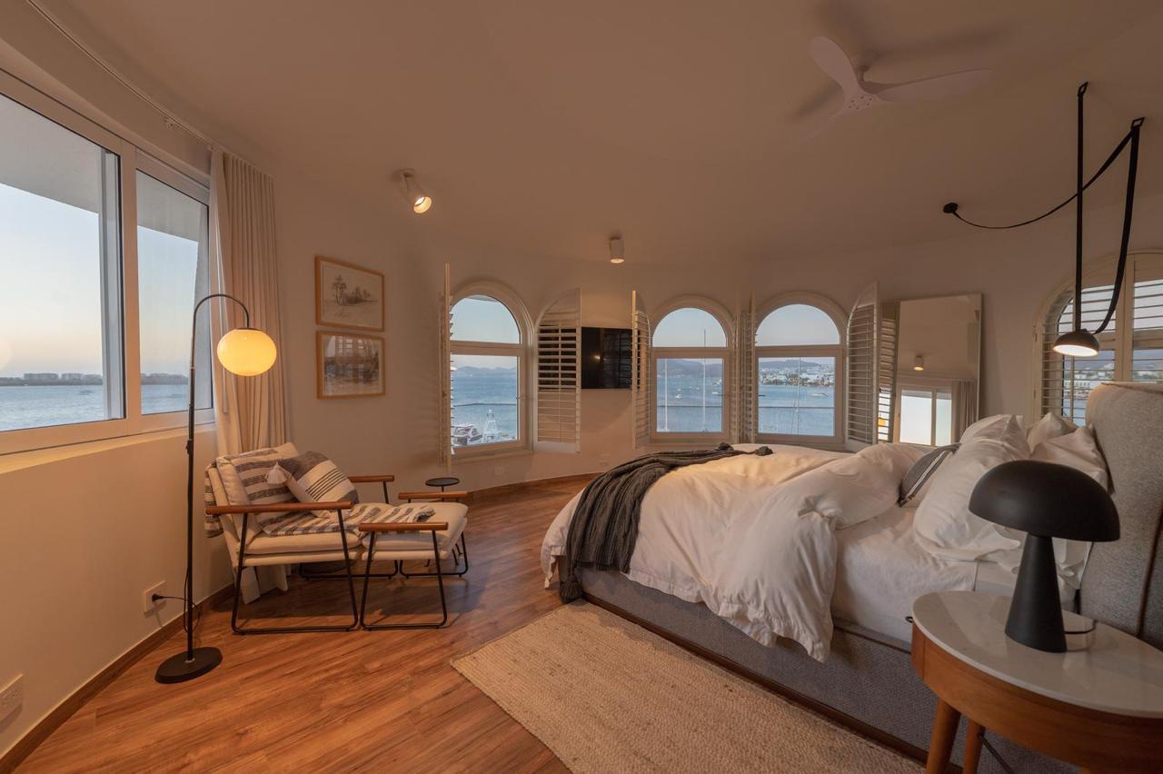 Your serene bedroom retreat features gleaming hardwood floors, a cozy seating nook by arched windows, and breathtaking water views that greet you each morning.