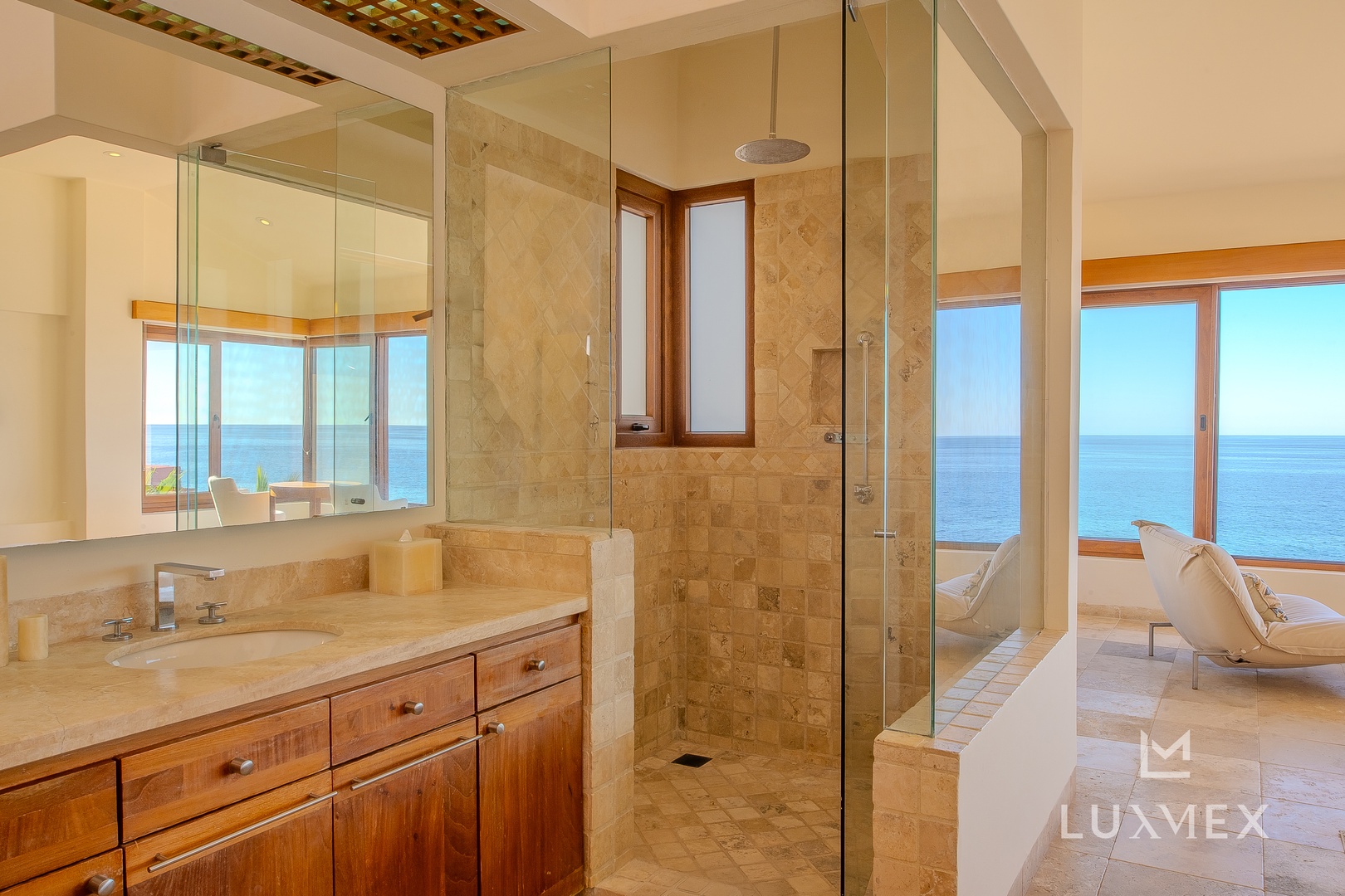 Your spa-like bathroom offers marble luxury with ocean views, inviting you to unwind in elegance.