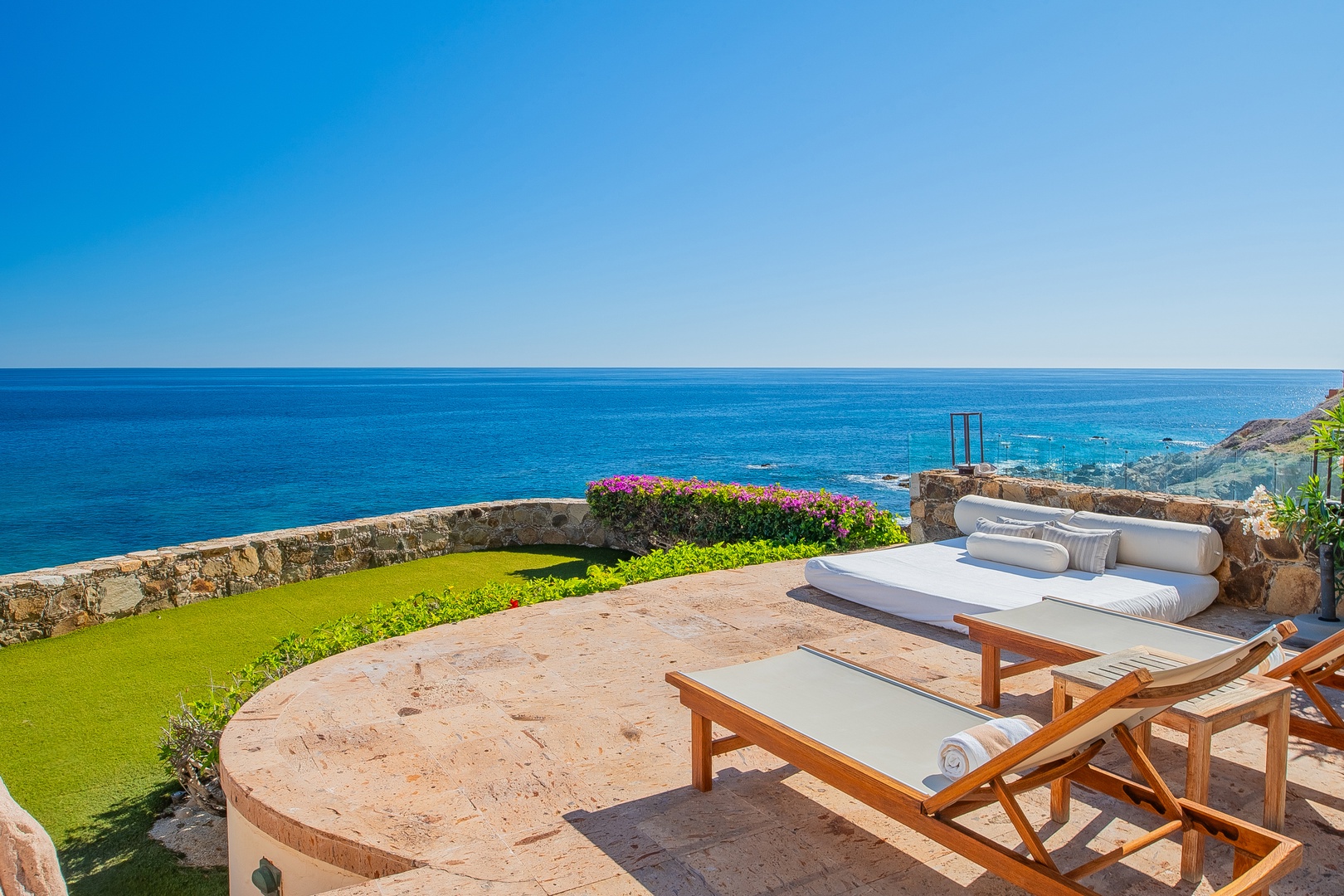 Picture yourself lounging on your private terrace, soaking in endless ocean views where vibrant blooms meet the sparkling blue horizon—your perfect seaside escape awaits.