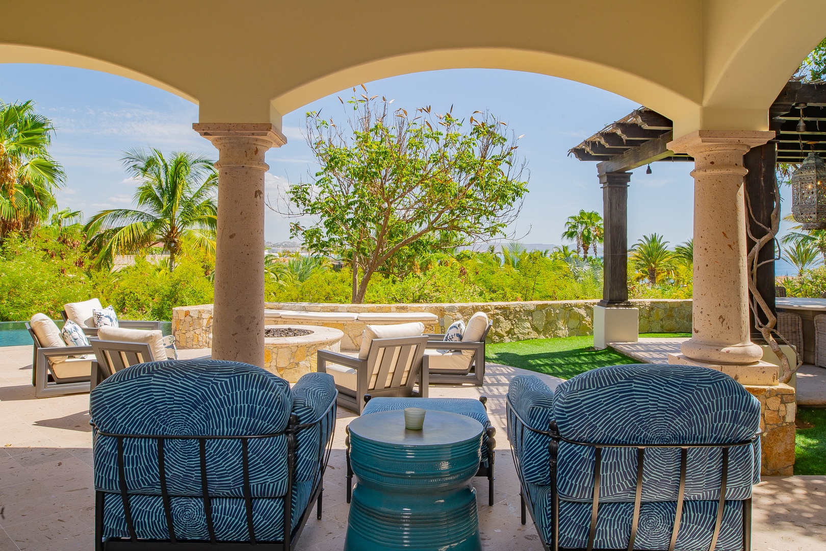 Settle into the shaded comfort of your private terrace, where elegant arches frame lush gardens and ocean glimpses beyond—perfect for sipping morning coffee or watching the day drift by.