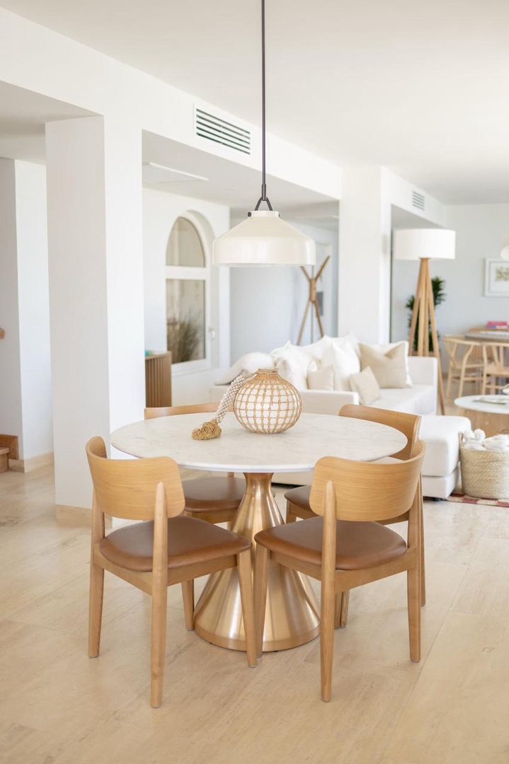Gather around this inviting round table where natural wood tones and soft white accents create your perfect spot for morning coffee or evening meals with loved ones.