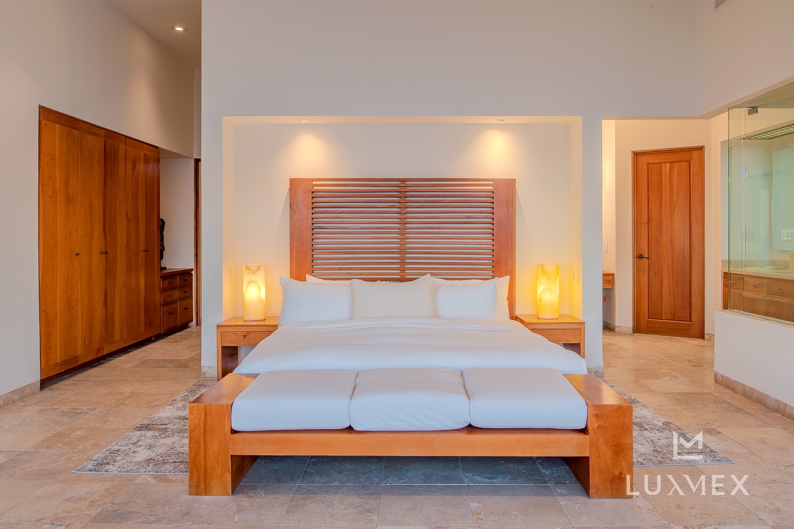 Sink into this luxurious king bed with crisp white linens and warm wood details for your perfect night's rest.