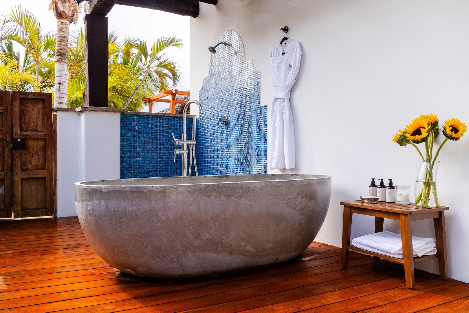 Soak in your stunning stone tub overlooking lush palms, with luxurious toiletries and a plush robe waiting for ultimate relaxation.