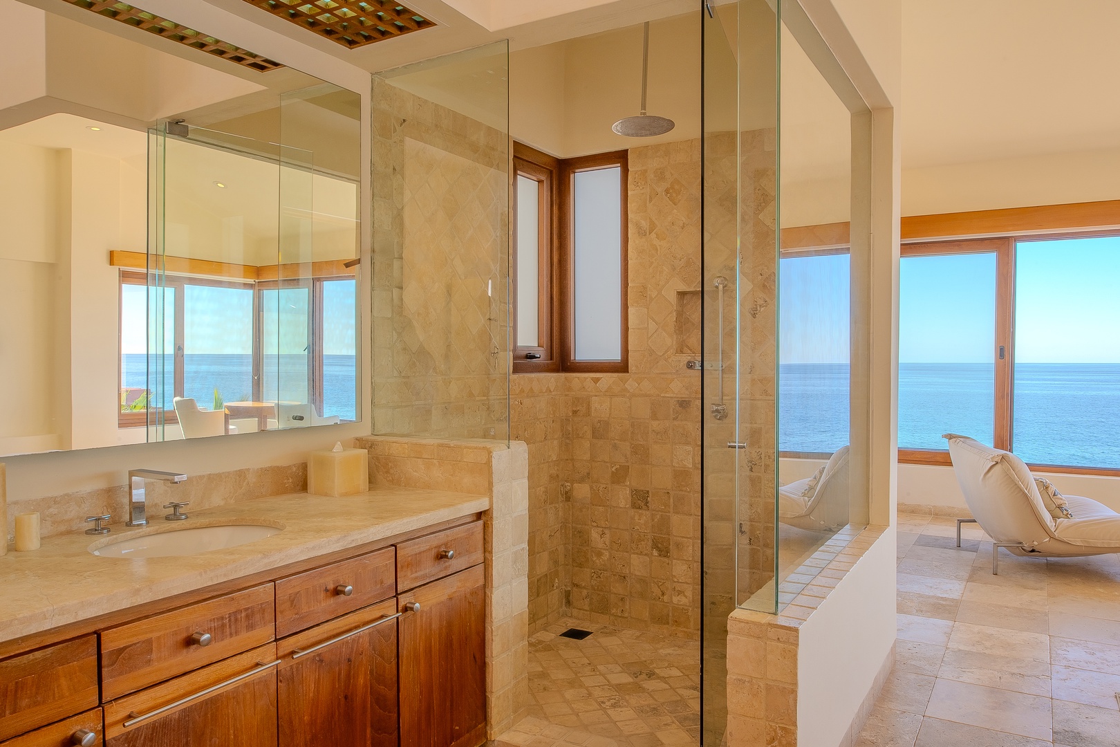 Stunning sea views frame your private spa-like sanctuary, where sunlight pours through floor-to-ceiling windows and a spacious walk-in shower invites you to unwind.