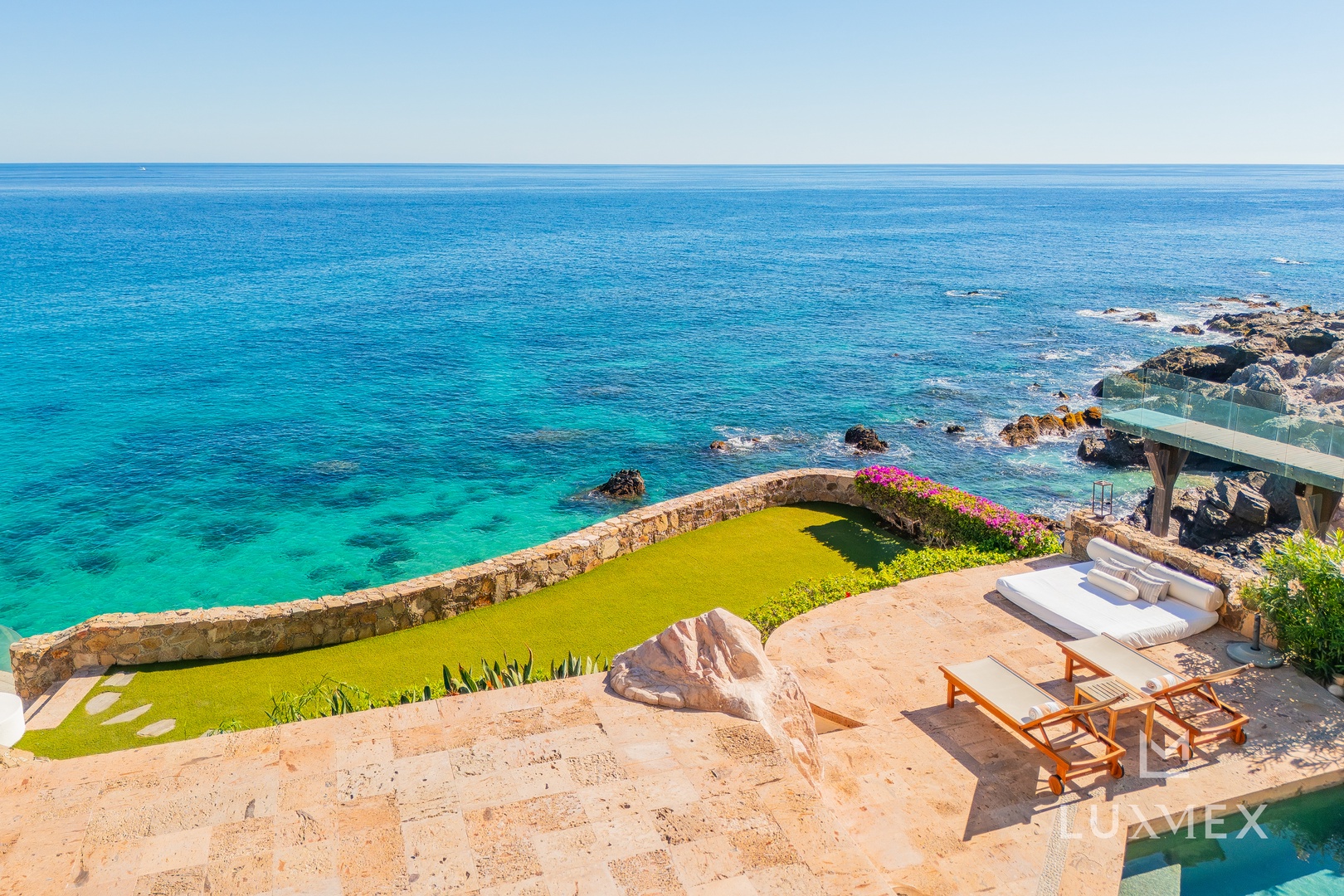 Stunning oceanfront terrace with crystal-clear turquoise waters stretching to the horizon and perfectly positioned loungers.