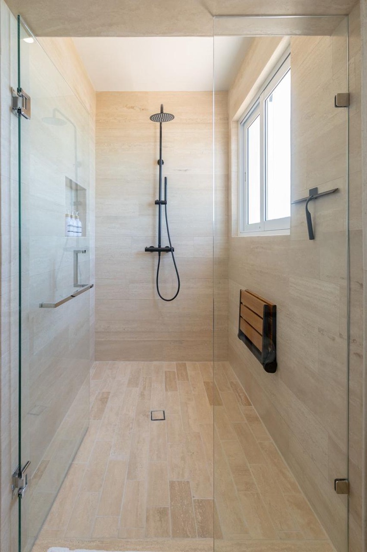 Step into your private spa-like shower with elegant tile work, rainfall showerhead, and natural light from the window—perfect for refreshing mornings.