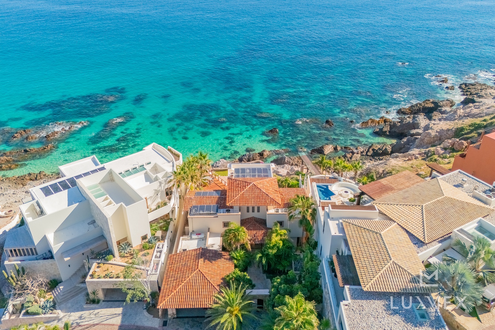 Coastal paradise with crystal-clear turquoise waters and Mediterranean-style villas nestled along pristine shoreline.