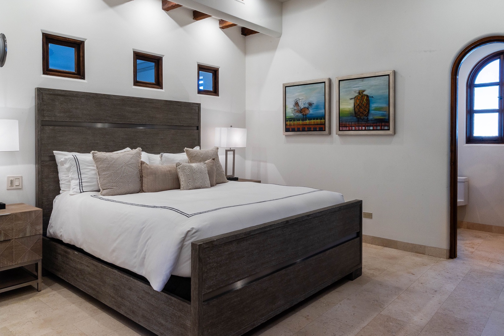 Sink into crisp linens and layered textures in your serene bedroom retreat, where vaulted ceilings and thoughtful artwork create a calming escape after days of exploration.