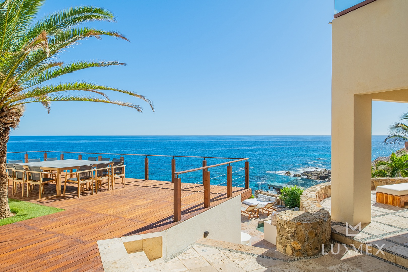 Stunning oceanfront terrace with panoramic sea views and tropical palm trees creating the perfect coastal retreat.