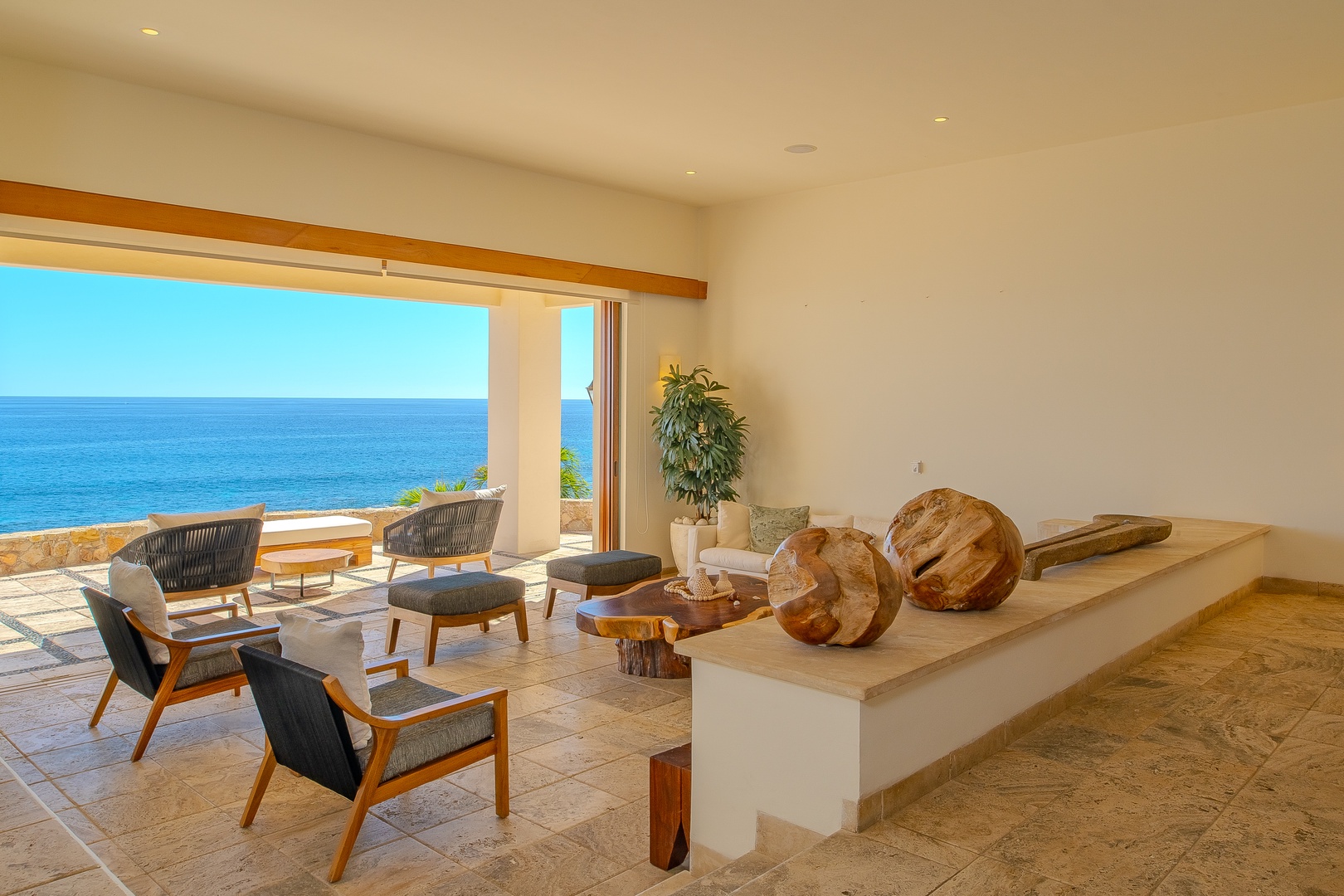 Picture yourself unwinding in this serene lounge, where natural wood accents and soothing coastal blues create the perfect retreat. Your private terrace frames endless ocean views, inviting you to relax and breathe in paradise.