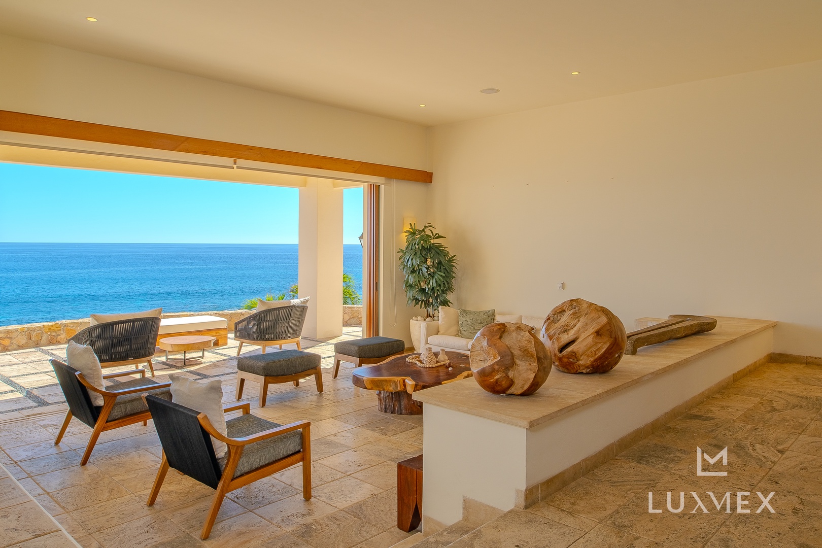 Sink into comfortable seating while taking in the stunning ocean views through your floor-to-ceiling windows in this serene living space.