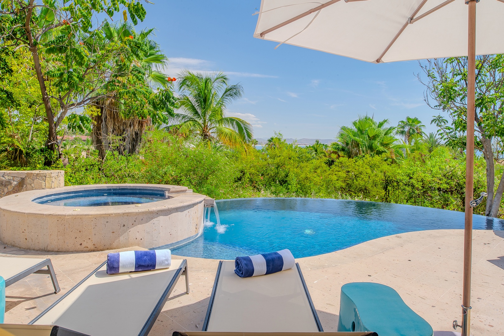 Soak in your private infinity pool overlooking lush tropical gardens, with a built-in hot tub and shaded loungers waiting for you to unwind in paradise.