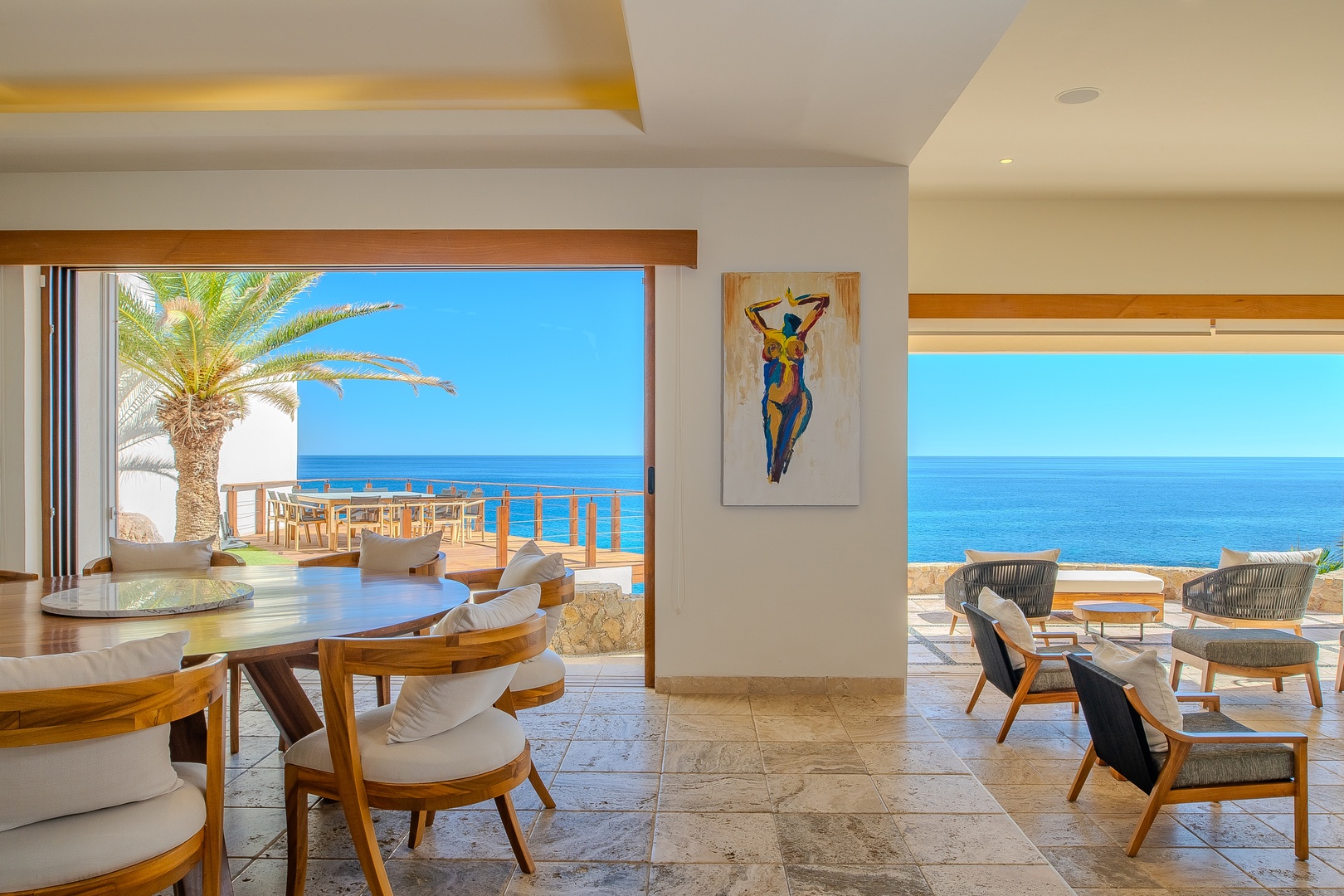 Bright, open living and dining area with sweeping ocean views, modern furnishings, and tropical accents. Your perfect retreat for relaxing after sun-soaked beach days.