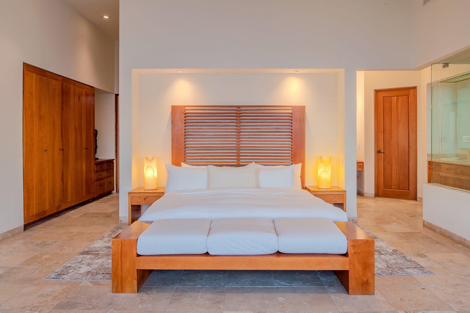 Sink into your plush king bed framed by warm wood accents and ambient lighting, creating a serene sanctuary for restful nights. The spacious layout and soft tones invite you to unwind completely.