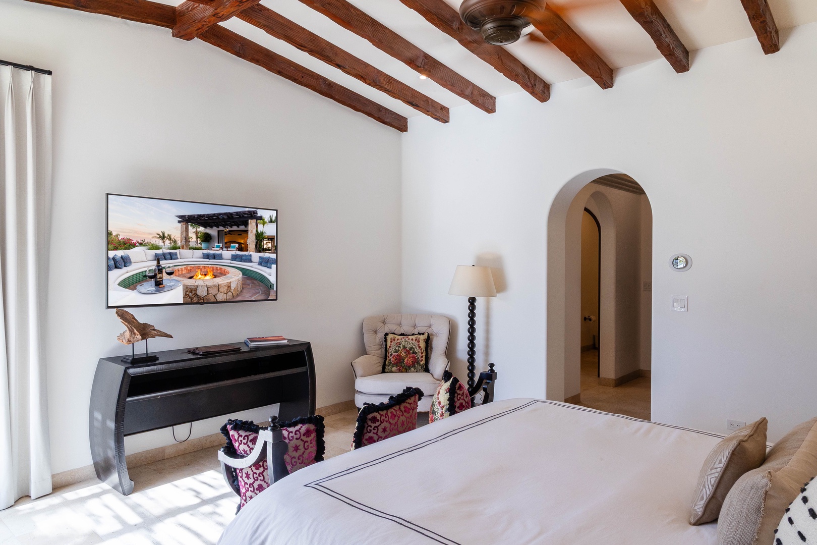 Your peaceful bedroom retreat features rich wooden ceiling beams and elegant archways, creating a serene space where you'll wake refreshed each morning.