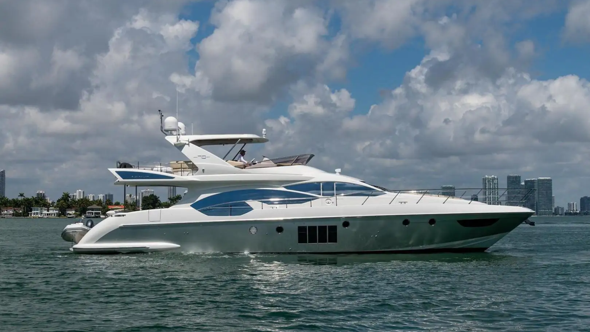 Luxury yacht available for charter with stunning Miami skyline backdrop and crystal-clear waters.
