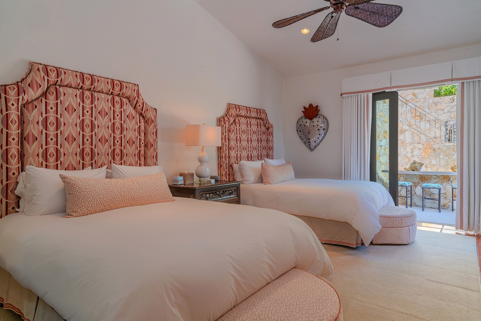 Wake up in this charming bedroom where plush linens and designer touches meet your private balcony access. Soft coral accents and thoughtful lighting create your perfect retreat after a day of adventure.