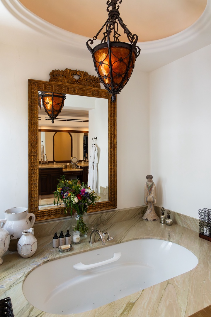 Sink into this elegant soaking tub, surrounded by warm Mediterranean details and soft lighting. Fresh flowers and curated bath amenities await your arrival, promising pure relaxation.
