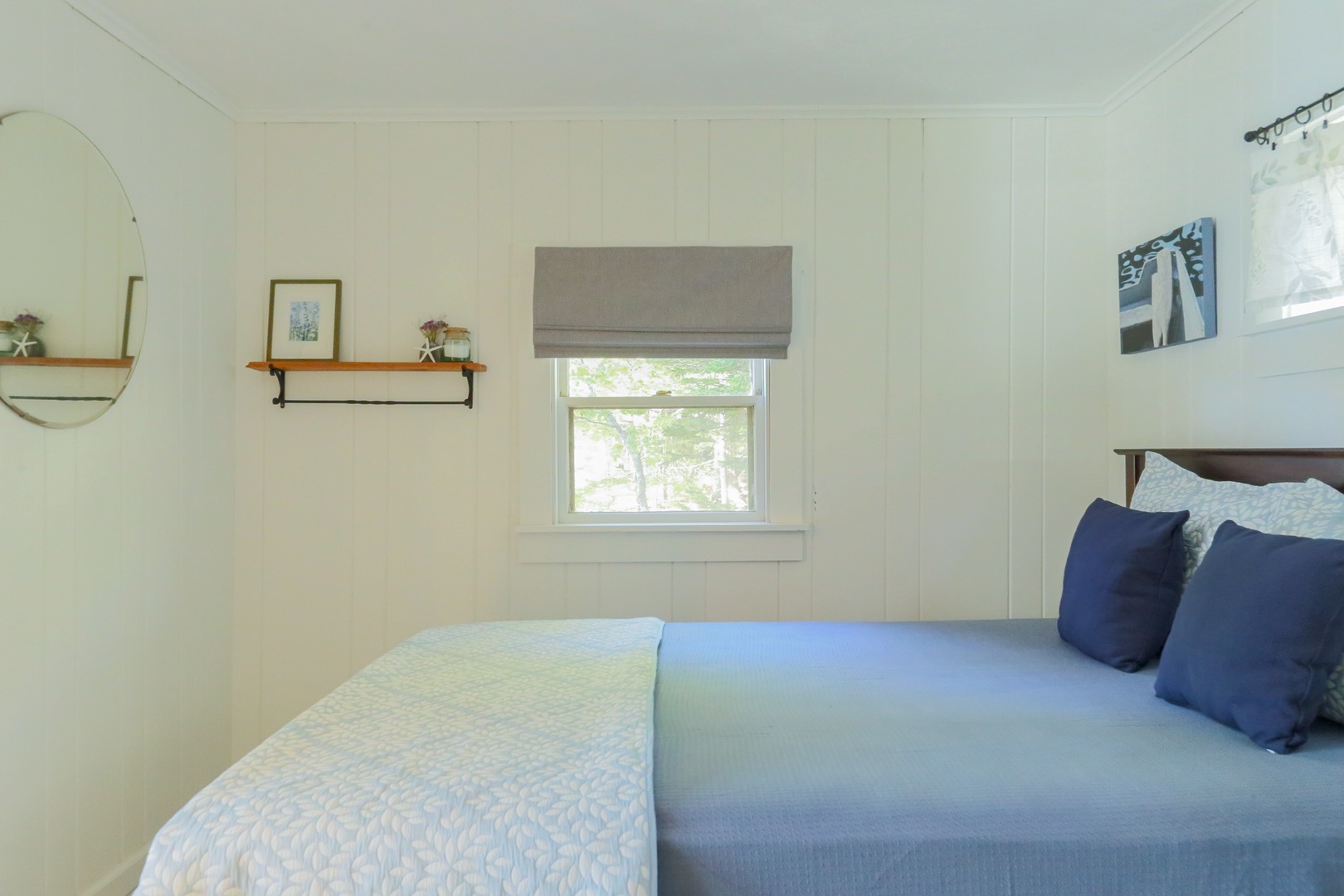 Unwind in your serene bedroom, where crisp white shiplap and soft coastal tones create a calming retreat after a day of seaside adventures.