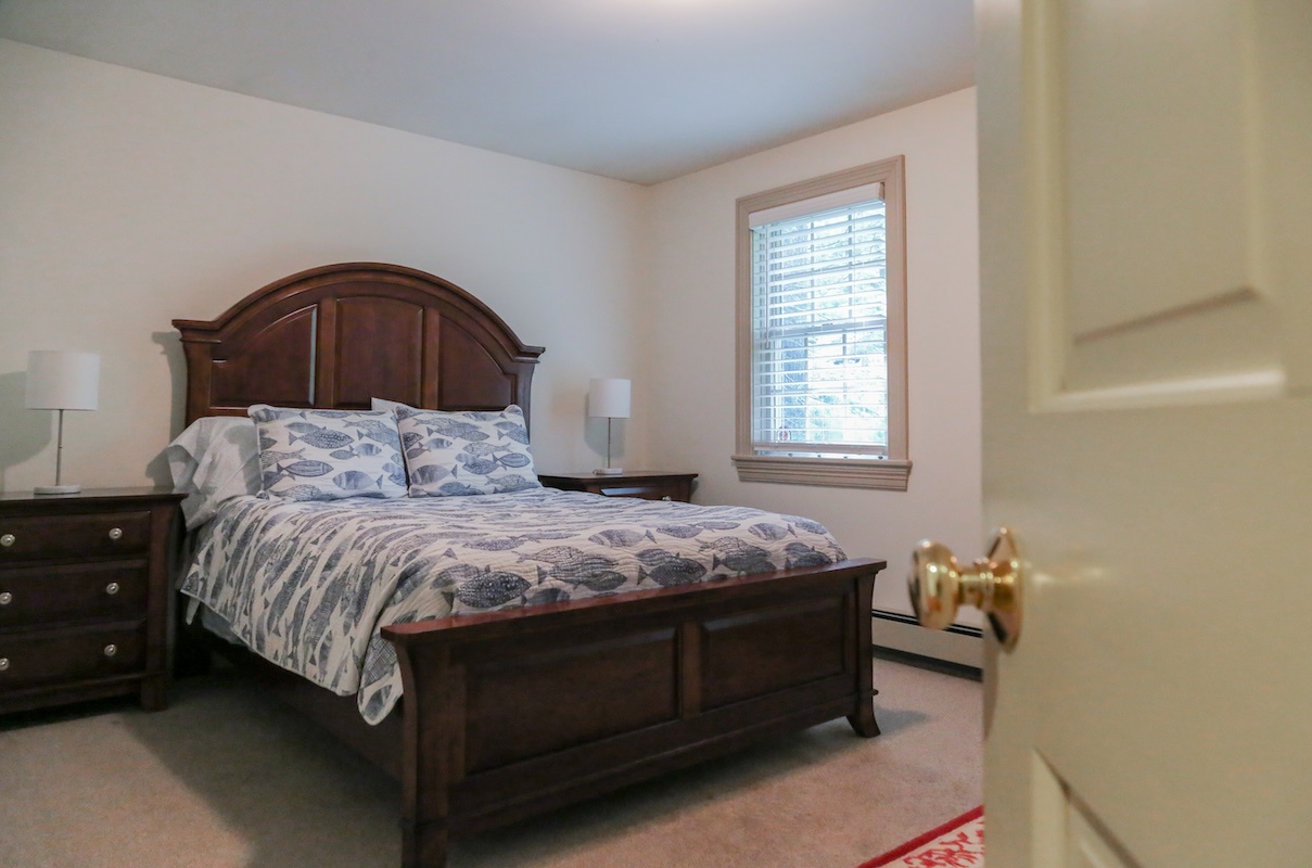 Step into your restful retreat with a beautifully crafted bed and soft natural light streaming through the window. Your cozy escape awaits.